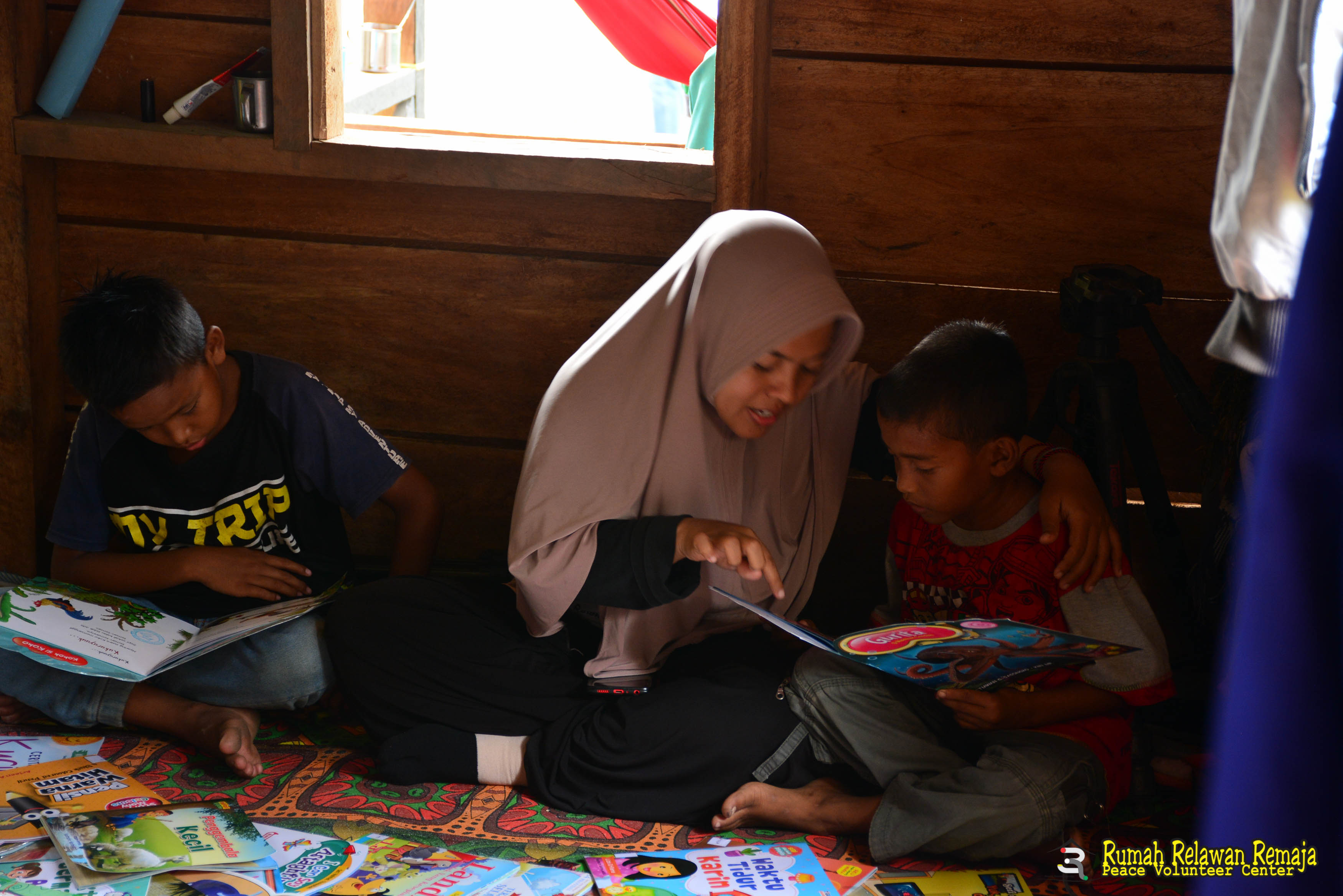 Supriadi (Usup) sedang belajar membaca dengan guru Pustaka Kampung Impian